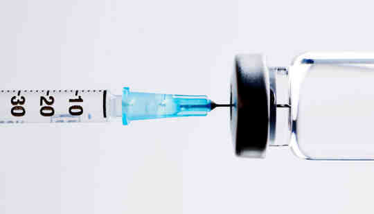 An insulin syringe draws from a glass vial