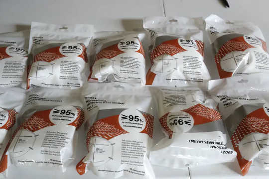 A table with various brands of KN-95 masks in packaging