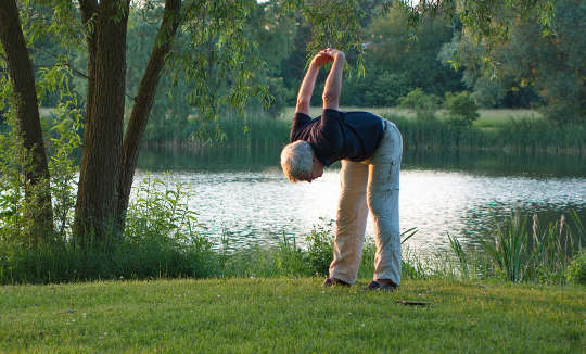 a woman stretching outside in a park
