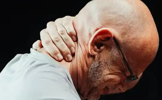 a man holding his neck in pain