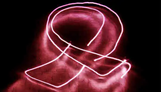 A pink light trail in the shape of the breast cancer awareness pink ribbon