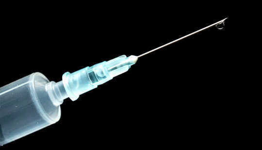 A syringe against a black background