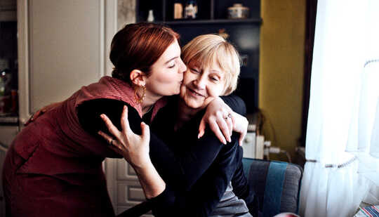 A younger woman hugs her mother